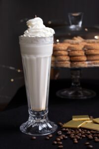 creamy homemade vanilla milkshake in a serving glass